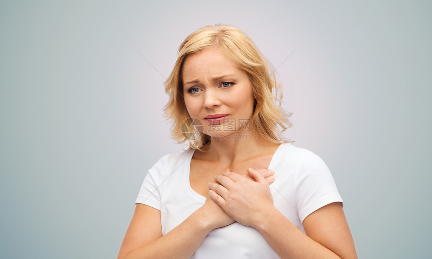 人,医疗,心脏病问题的幸的女人遭受心痛的灰色背景图片