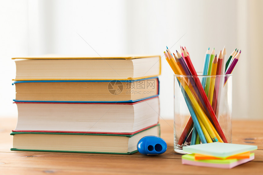 教育学校创造力象把蜡笔彩色铅笔与书贴纸卷笔刀放木桌上图片