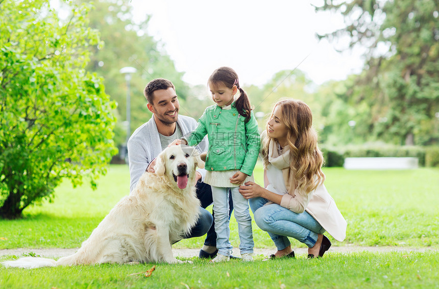 家庭,宠物,家畜人的快乐的家庭与拉布拉多猎犬夏季公园散步图片