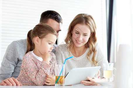 家庭,父母,技术人的快乐的母亲,父亲小女孩与平板电脑电脑餐厅吃饭图片