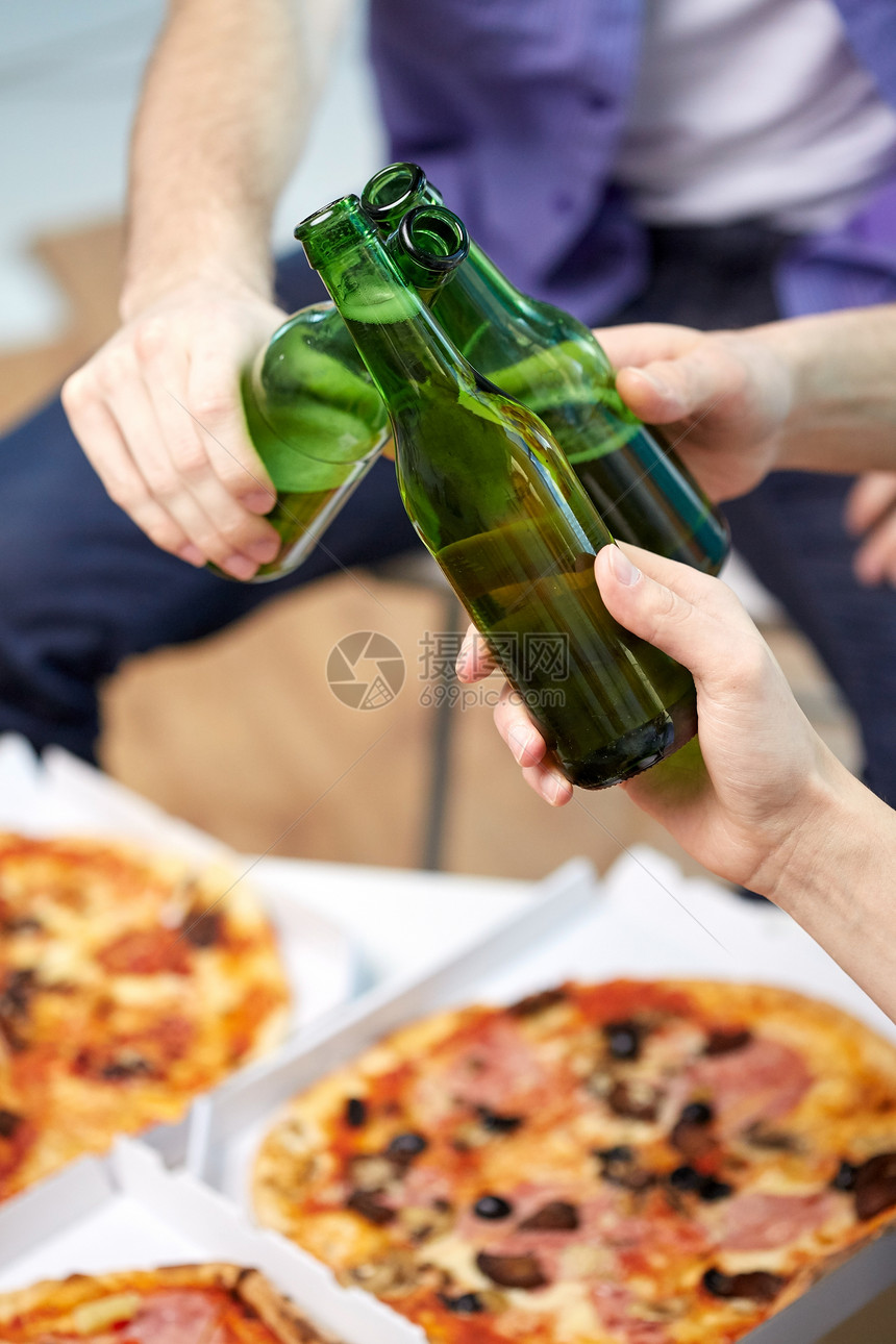 友谊,酒精,人,庆祝节日的男的手,家里碰啤酒瓶吃比萨饼图片