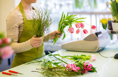 人,商业,销售花卉花店的花店妇女制作郁金香图片