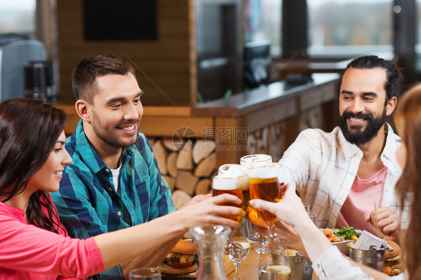 休闲,饮食,食物饮料,人假日的微笑的朋友餐馆酒吧吃晚餐喝啤酒图片