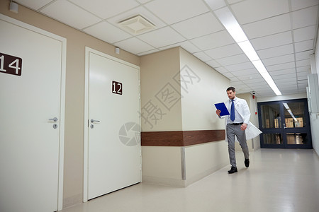 诊所,人,保健医学医生与剪贴板步行沿医院走廊图片