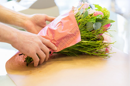 人,购物,销售,花卉消费观念花店花店的花匠用纸裹花背景图片
