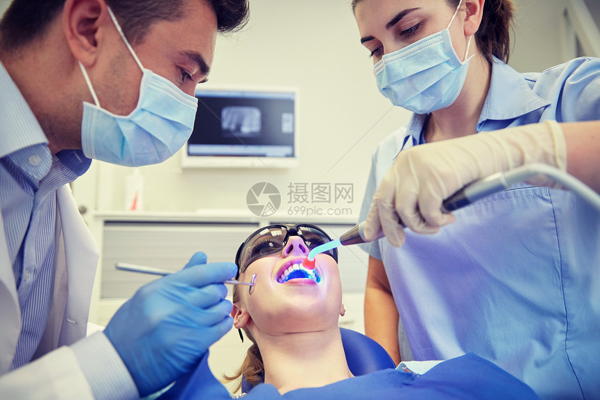 人,医学,口腔医学保健男牙医助理与牙科治疗光镜子治疗女病人牙齿牙科诊所办公室图片