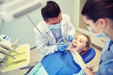 人,医学,口腔医学保健男牙医助理牙科镜,钻空气水喷雾治疗女病人牙齿牙科诊所图片