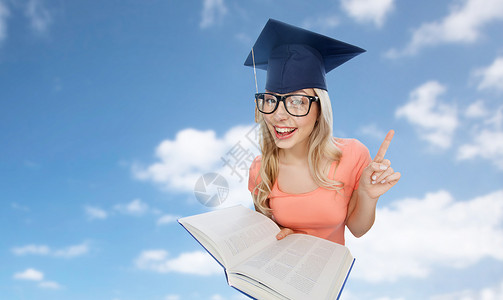 人,教育,知识毕业微笑的轻学生妇女黑板眼镜与百科全书书籍指向蓝天云背景图片