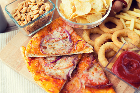 快餐健康的饮食观念比萨饼其他小吃木制桌子上快餐小吃桌子上的饮料图片