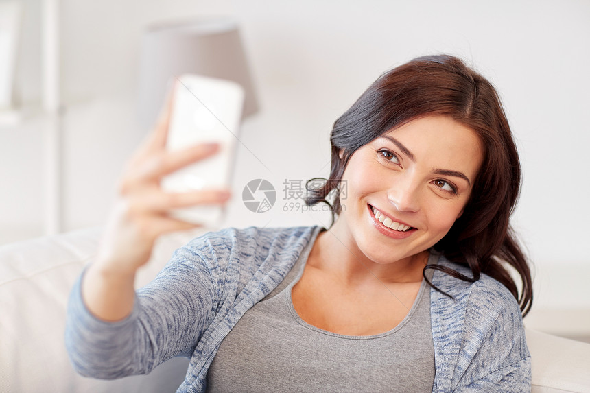 人,技术休闲快乐的女人家里用智能手机自拍图片