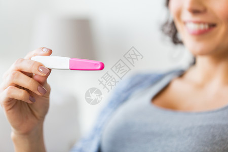 怀孕,生育,生育人的密切快乐微笑的女人与家庭怀孕测试图片