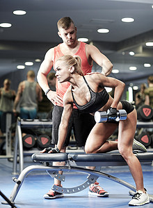 健身,运动,锻炼,健美举重的轻妇女私人教练与哑铃弯曲肌肉健身房图片