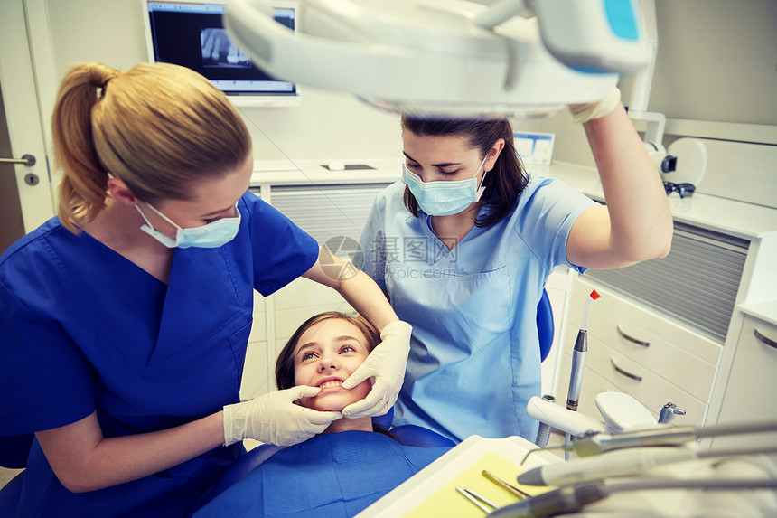 人,医学,口腔科牙齿护理快乐的女牙医与助理检查病人女孩牙合牙牙科诊所办公室图片