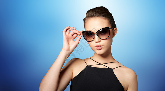 配饰,眼镜,时尚,人奢侈的美丽的轻女人穿着优雅的黑色太阳镜蓝色背景图片