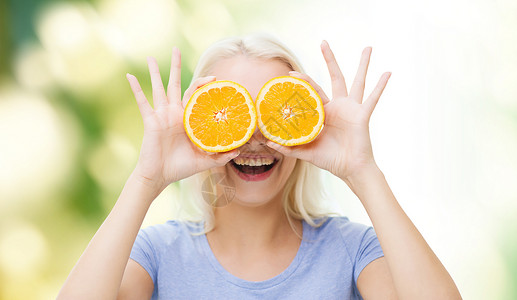 三无食品漫画健康饮食,机食品,水果饮食,漫画人的快乐的女人玩得开心,用橙色的切片覆盖她的眼睛绿色的自然背景背景