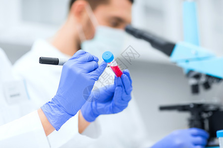 科学化学技术生物学人的科学家们用标记试管上写字,并临床实验室进行研究图片
