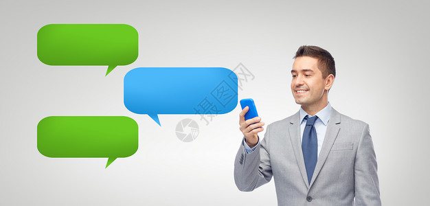 商业,人,通信技术快乐的商人短信阅读信息智能手机上的信短信泡泡灰色背景图片