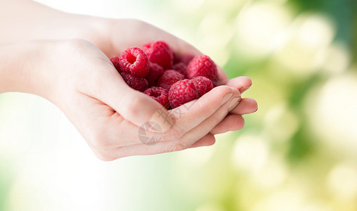 健康的饮食,节食,素食人们的靠近女人的手树莓绿色的自然背景图片