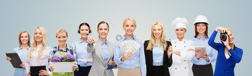 人,职业,就业,薪酬财务快乐的女商人持美元的钱与群专业工人蓝色背景图片