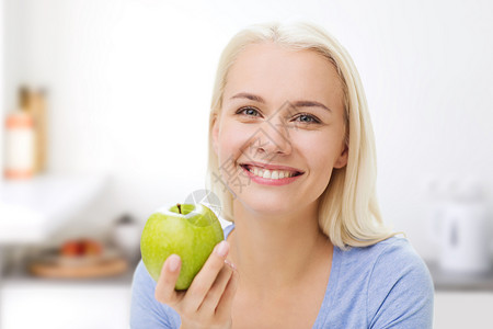 健康饮食,机食品,水果,饮食人的快乐的女人吃绿色苹果厨房背景图片
