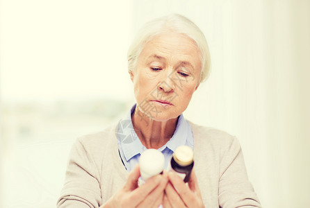 龄,医学,保健人的老妇女看着罐子家里医院办公室的药物图片