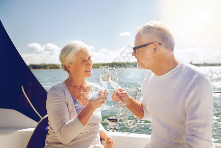 龄璃杯航海,龄,旅行,假期人们的快乐的老夫妇海上漂浮的帆船游艇甲板上碰碰香槟杯背景
