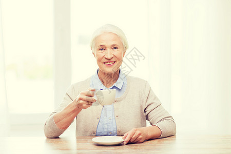 龄,饮料人的快乐的微笑老妇女家里喝杯咖啡图片