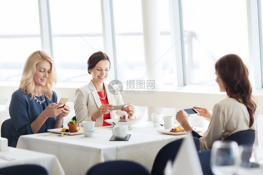 人,技术生活方式的快乐的女人用智能手机餐厅拍照食物图片