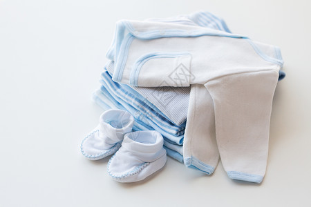 服装,婴儿,母亲象白色婴儿羊毛衫与靴子堆衣服为新生男孩背景图片