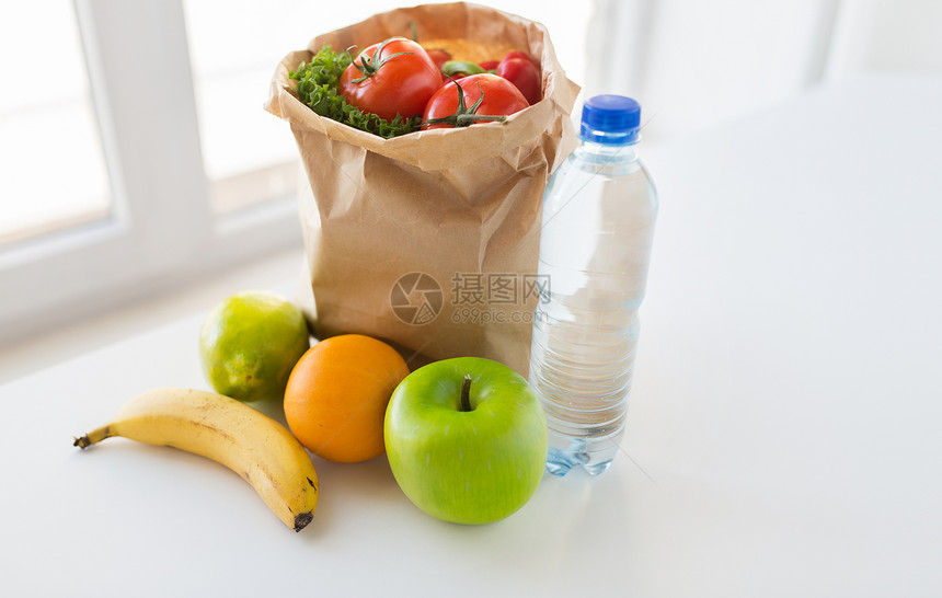 烹饪,饮食,素食健康饮食纸袋与新鲜成熟多汁的水果蔬菜水瓶厨房的桌子上图片