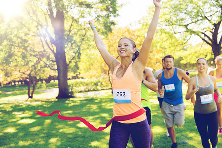 健身,运动,胜利,成功健康的生活方式快乐的女人赢得比赛,并率先完成红色丝带超过运动员跑马拉松与章号码户外背景