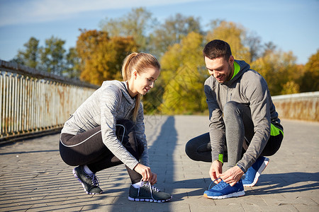 健身,运动,训练,人生活方式的微笑的夫妇系鞋带的运动鞋户外图片