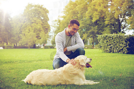 家庭,宠物,动物人的快乐的人与拉布拉多猎犬城市公园散步图片