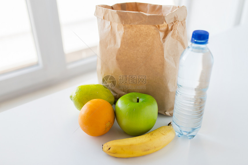 烹饪,饮食,素食健康饮食纸袋与新鲜成熟多汁的水果水瓶厨房的桌子家里图片