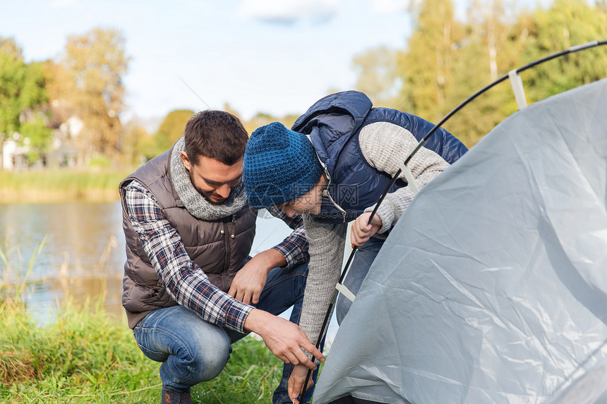 野营,旅游,远足,家庭人的快乐的父子户外搭帐篷图片