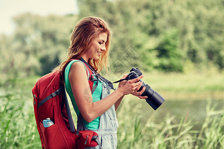 冒险,旅行,旅游,徒步旅行人们的快乐的轻女人带着背包相机户外拍照图片