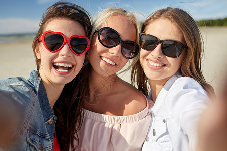 暑假,假期,旅行人的群微笑的轻女海滩上自拍图片
