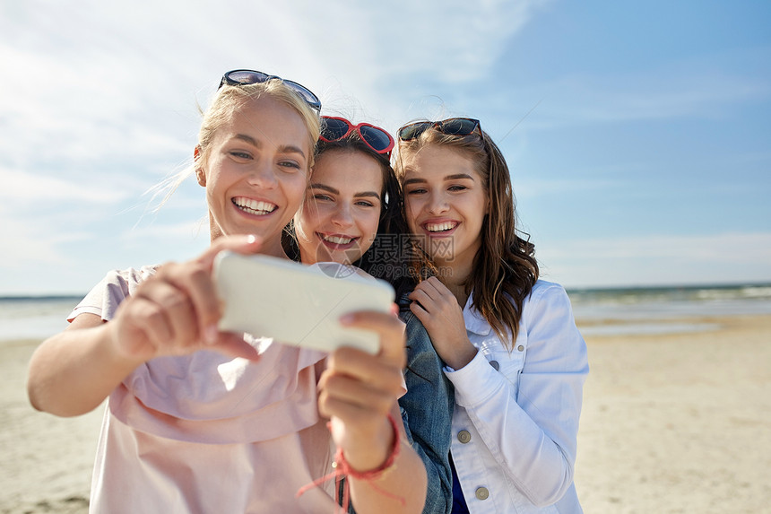 暑假,假期,旅行,技术人的群微笑的轻妇女带着硫化物海滩上的智能手机图片