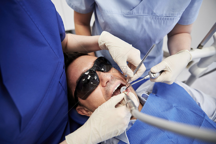人医学口腔医学保健理念牙科诊所用牙科镜钻头空气水喷雾治疗男患者牙齿图片