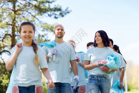 志愿服务慈善清洁人与生态群带垃圾袋公园散步的快乐志愿者图片