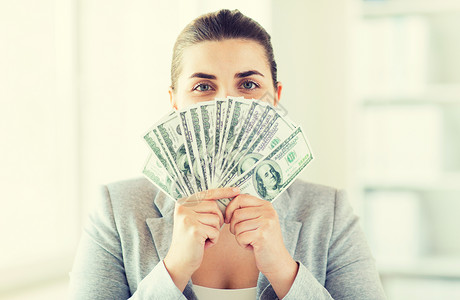 商业,金融,储蓄,银行人的近距离的女人隐藏她的脸背后的美元货币球迷图片