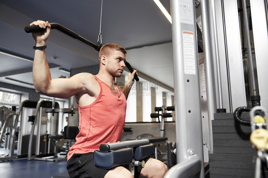 运动,健身,生活方式人的男人锻炼弯曲肌肉健身房的线电视机器图片
