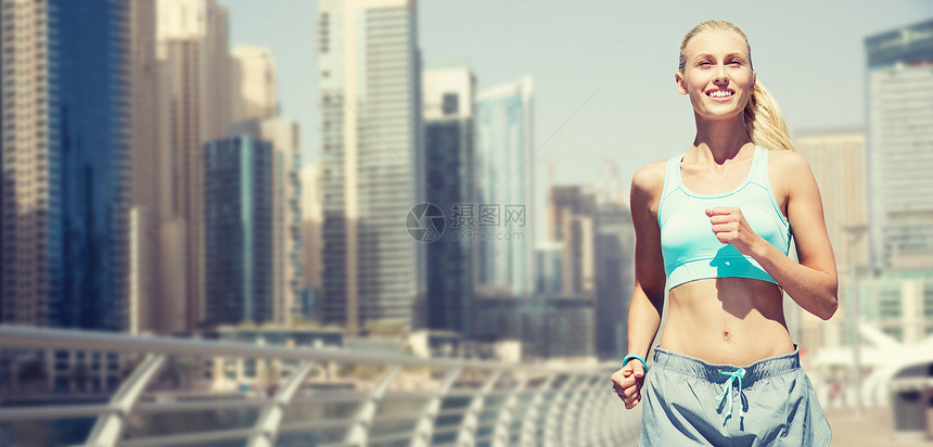 健身,运动,友谊健康的生活方式微笑的轻妇女跑步慢跑迪拜城市街道的背景图片