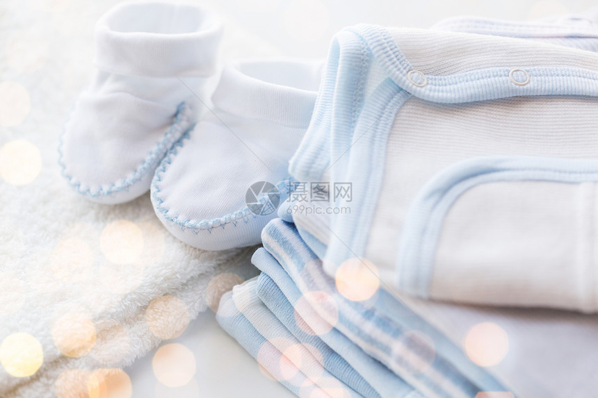 服装,婴儿,母亲象白色婴儿靴与堆衣服为新生男孩图片