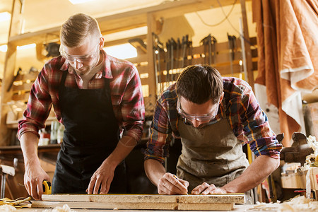 专业,木工,木工人的两个木匠与尺子测量木板车间图片