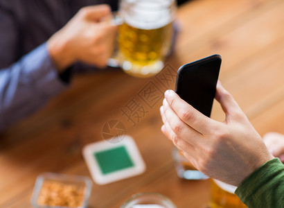 人,休闲,友谊技术亲密的两个男朋友喝啤酒与零食展示智能手机酒吧酒吧图片