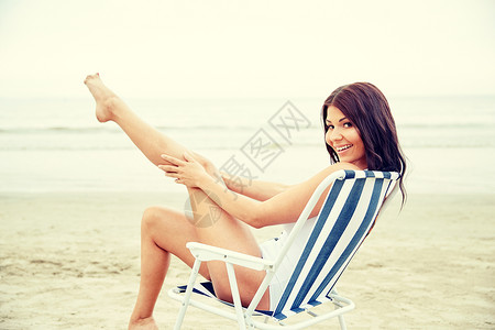 暑假,旅游,假日人们的微笑的轻女人休息室折叠椅海滩上日光浴图片