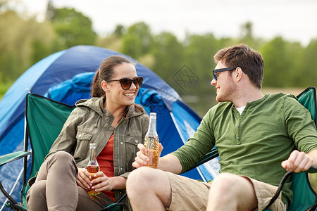 野营,旅行,旅游,徒步旅行人们的快乐的夫妇营地帐篷里喝啤酒苹果酒图片