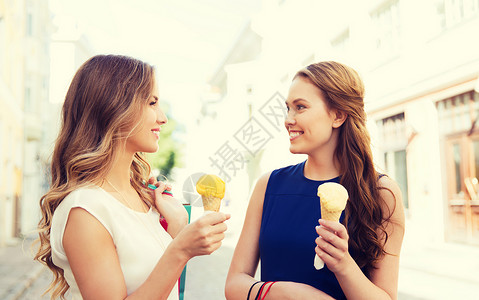 冰淇淋的女孩销售,消费主义,夏季人们的快乐的轻妇女与购物袋冰淇淋城市街道上交谈背景