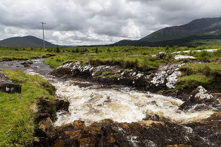 自然景观查看河流急流山丘山脉康奈马拉爱尔兰查看爱尔兰康奈马拉的河流山丘背景图片